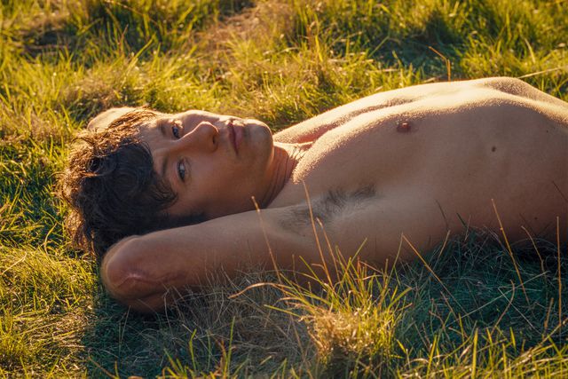 Man lying on grass in sunlight.