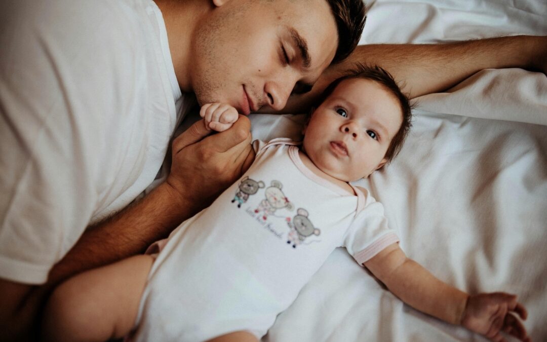 Father and baby lying on a bed