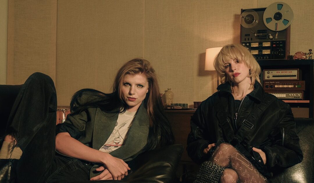 Two people sitting in a vintage recording studio.