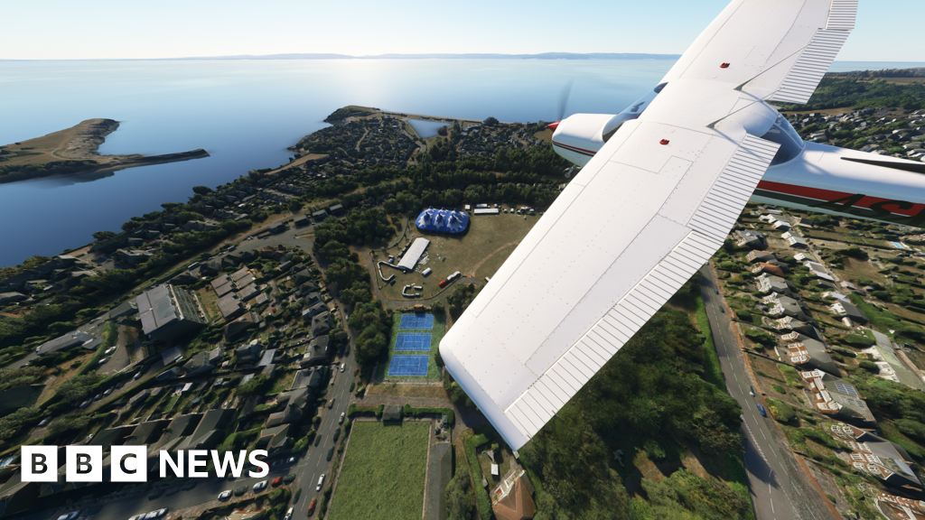 Small airplane flying over coastal town