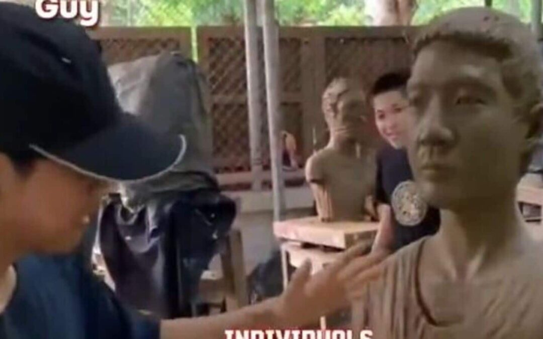 Person sculpting a clay bust in studio.