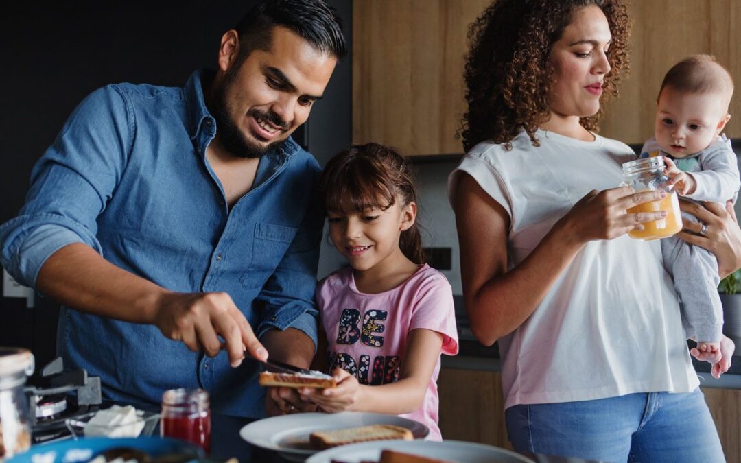 Family making breakfast together in kitchen.