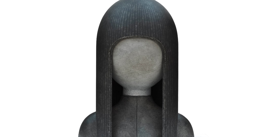 Sculpture of a humanoid figure with textured hair.