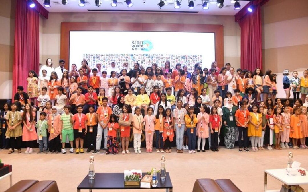 Large group at children's art event on stage.