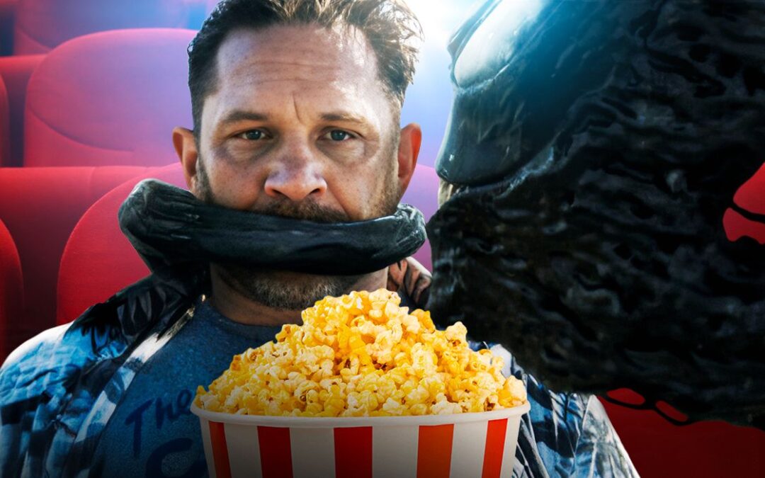 Man with alien in movie theater holding popcorn.
