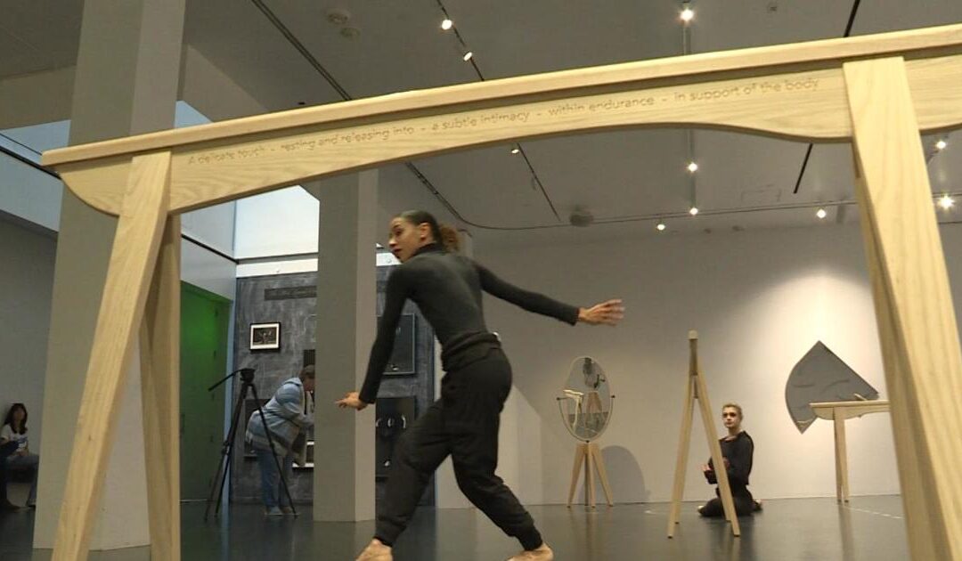 Dancer performing in modern art gallery installation.