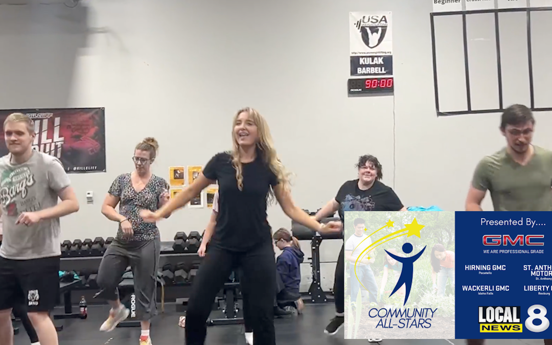 Group fitness class at gym with happy participants.