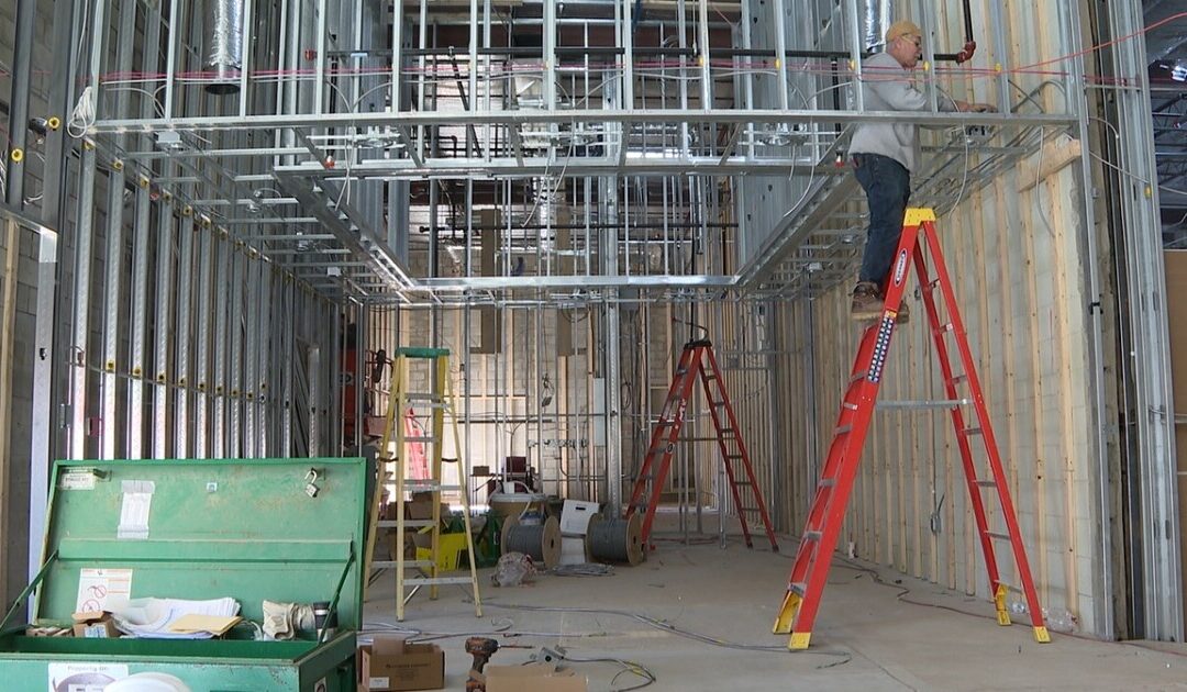 Worker on ladder in building under construction