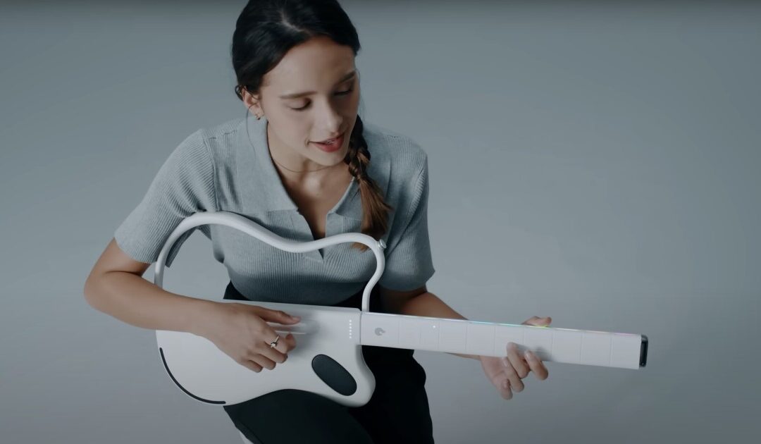 Person playing a modern white digital guitar.