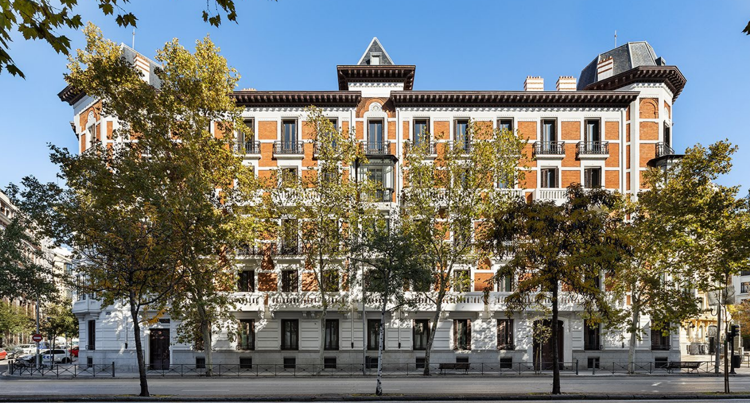 Historic red brick building with trees.